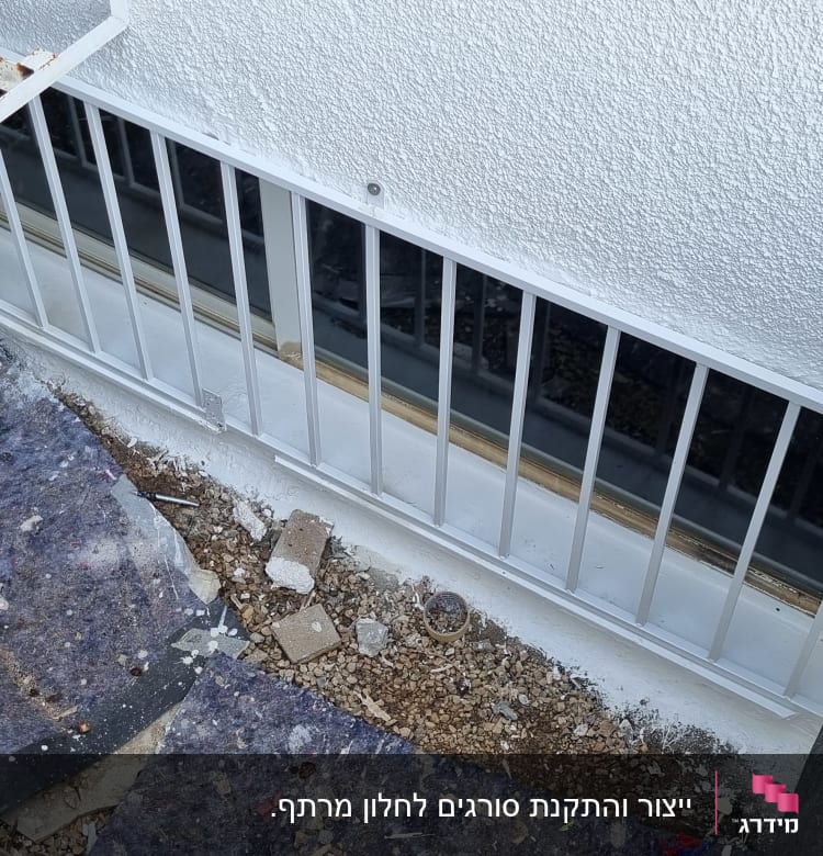 סורגי מתכת לבנים מותקנים על חלון קיר חיצוני